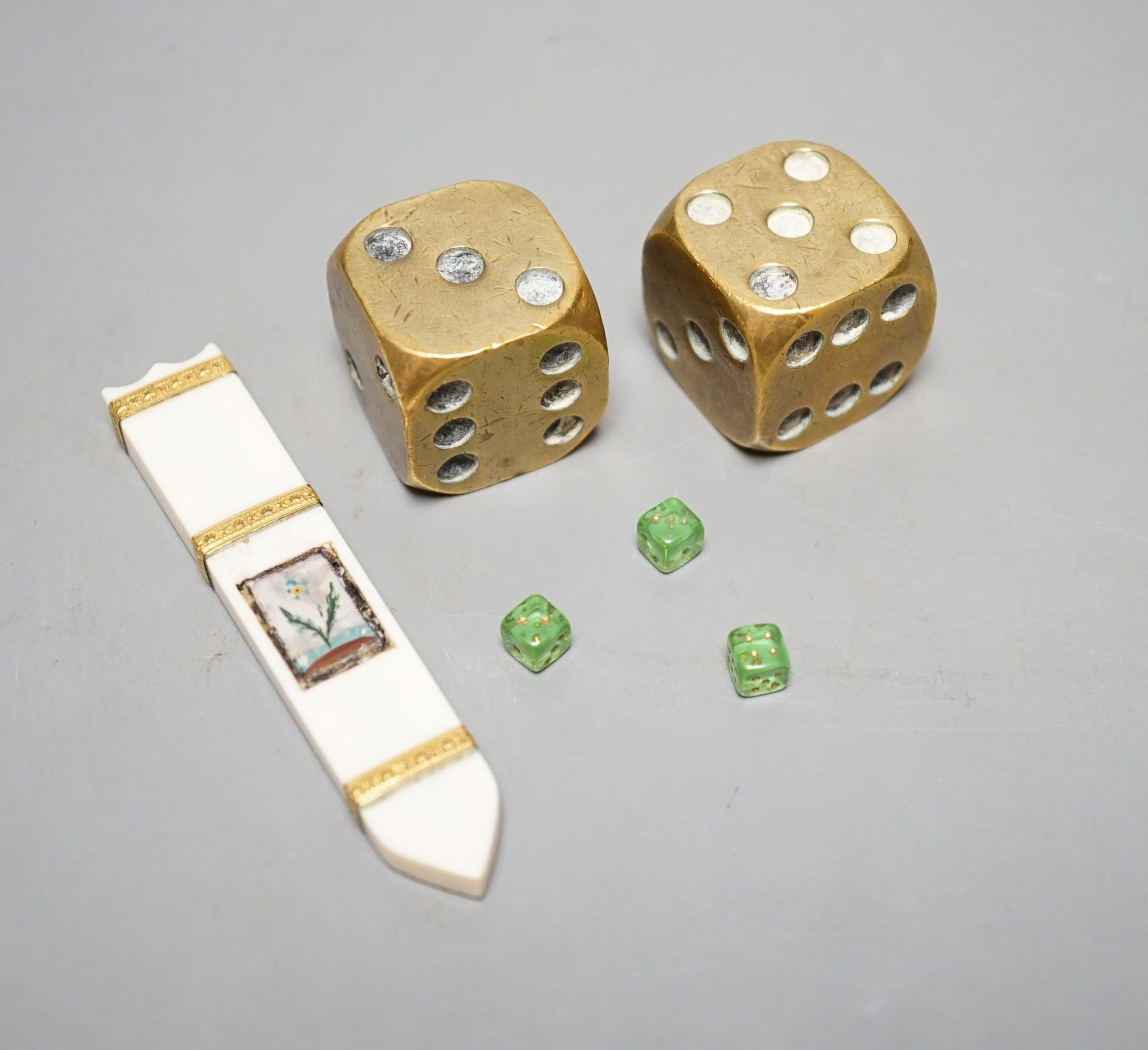A late 18th century ivory and gold mounted needle case, two brass dice and three mini dice
